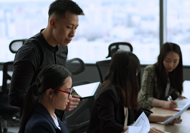 a group of professionals sitting at a table with papers
