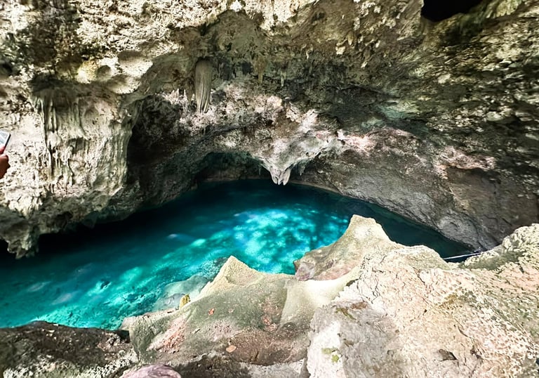 a man standing on a cliff face down into a cave santo domingo punta cana