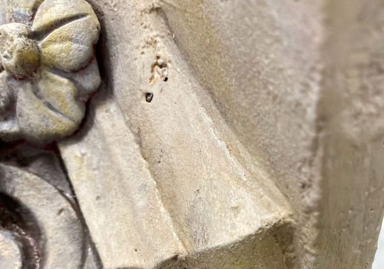 Close-up on capital of column with a painted sandstone faux finish.