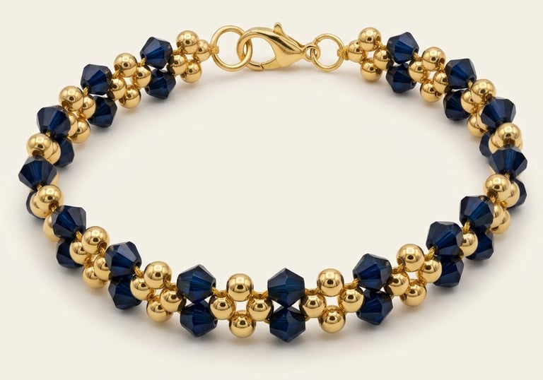 Elegant gold bead and blue sapphire crystal bracelet with a secure lobster clasp closure.