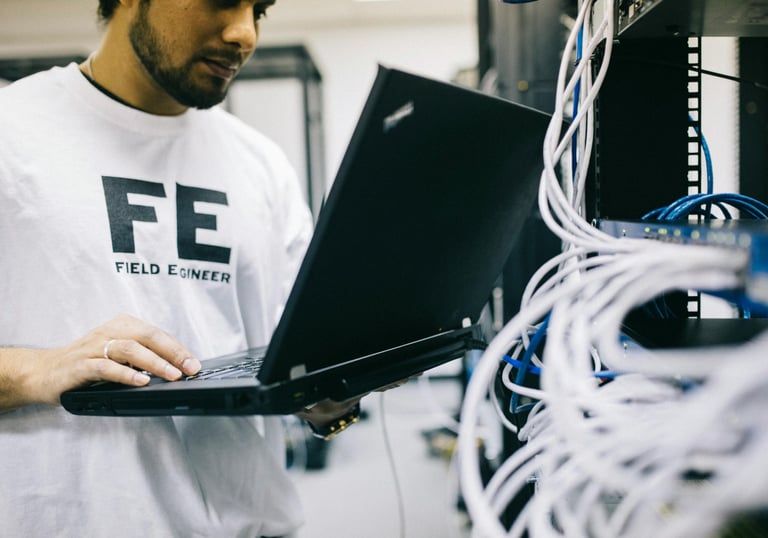 a man in a white shirt is holding a laptop computer