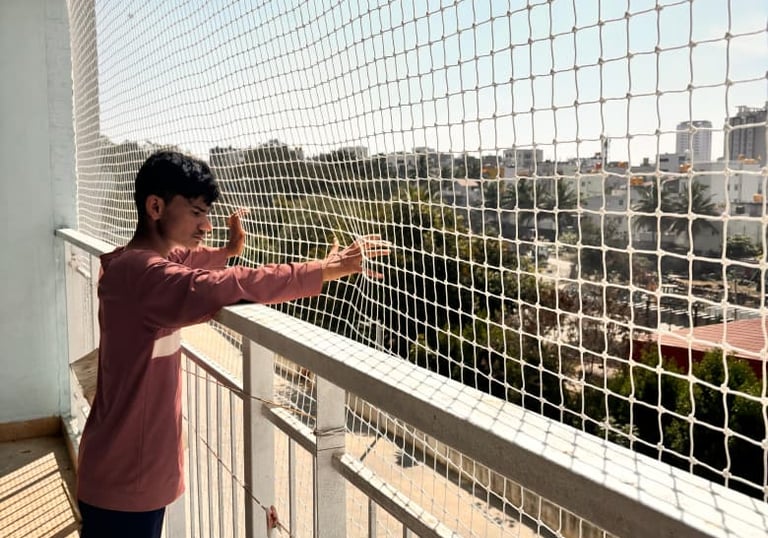 Close-up of hands inspecting the knots and mesh of a child safety net.
