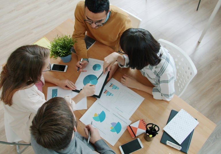 equipo de trabajo revisando y comentando gráficos y diagramas