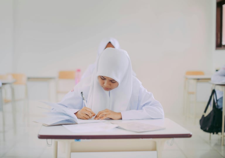 Malaysian student writing for SPM and UASA exam prep using visual learning for memory mastery with PNI Neuron.