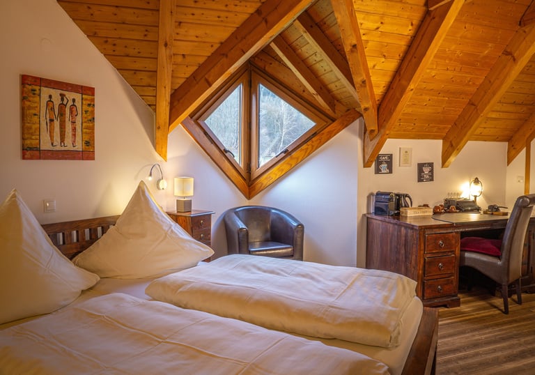 Ein gemütliches und helles Dachstudio-Zimmer einer Ferienwohnung mit rustikaler Holzverkleidung