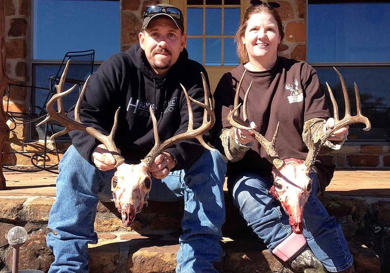 Brent and Vanya Keyser, owners of Loyal Valley Outfitters, posing with trophy deer mounts at their Mason County Texas ranch.