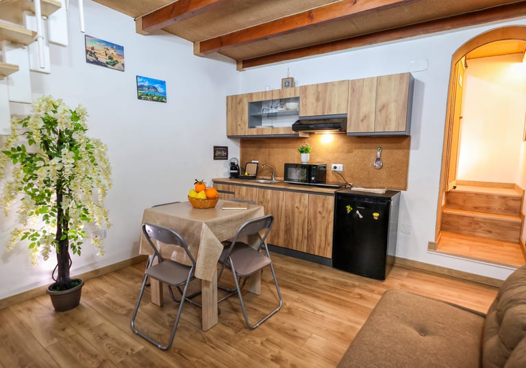 Cucina completa con piano cottura. microonde, macchina caffe', tavolo e sedie