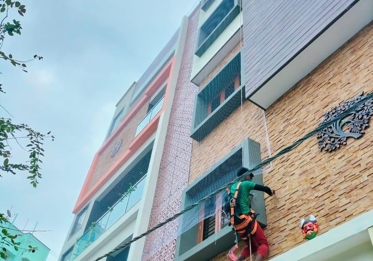 Technician carefully measuring a balcony for net installation in a residential area.