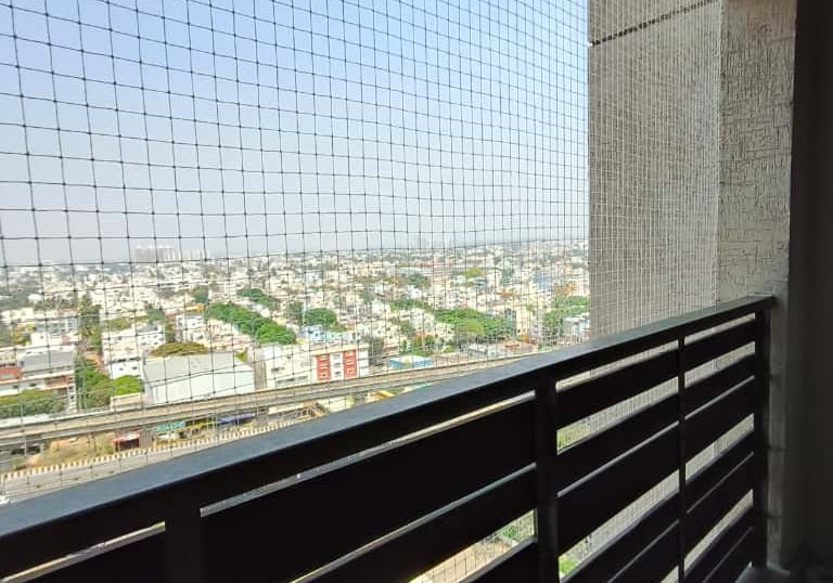 Technician from Arjilli Enterprises installing a balcony safety net with care.