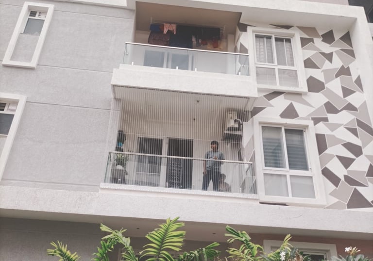 Wide view of a residential balcony fully covered with a sturdy safety net.
