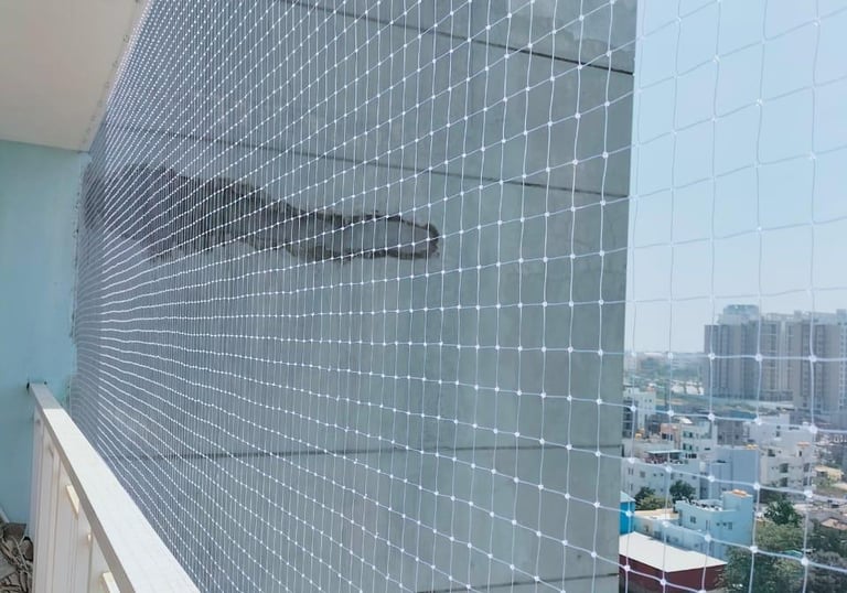 Technician carefully installing a safety net on a residential balcony.