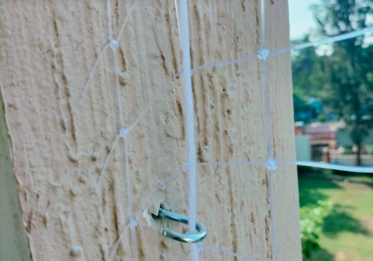 A technician installing anti pigeon nets on a residential balcony in Chennai.