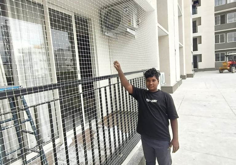 Technician installing a strong safety net on a residential balcony in Tambaram.