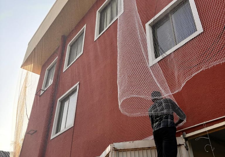 Close-up of fine mesh pigeon netting installed on a balcony railing.