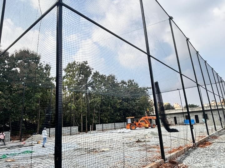 Wide shot of a freshly installed tennis court net under bright daylight.