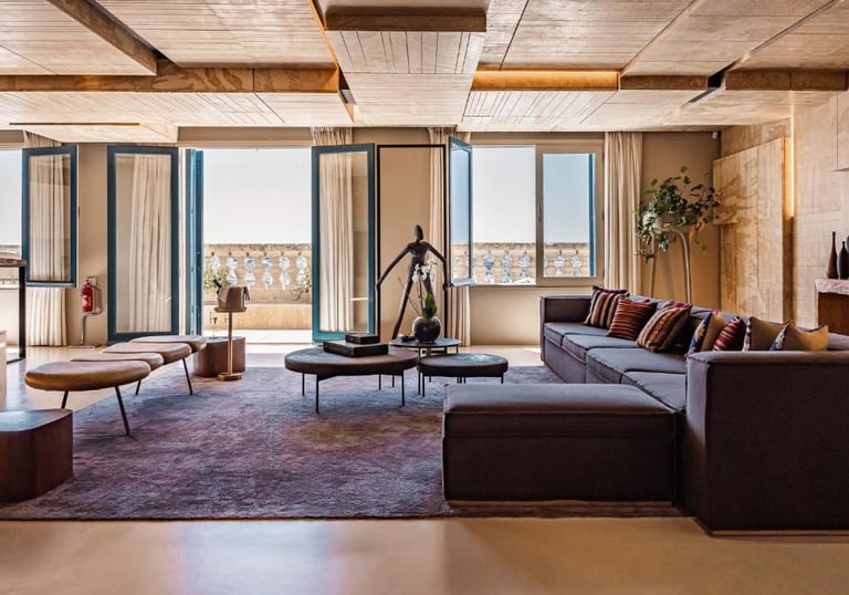 Modern luxury living room with a grey sectional sofa, wood paneled ceiling, and balcony doors.