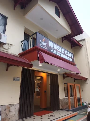 a building with a red awning and a sign that says music cafe