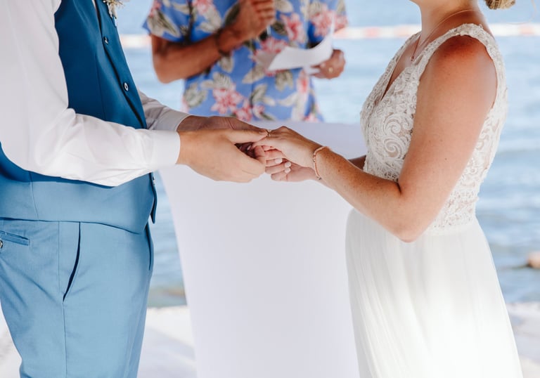 a bride and groom holding hands while they are getting married
