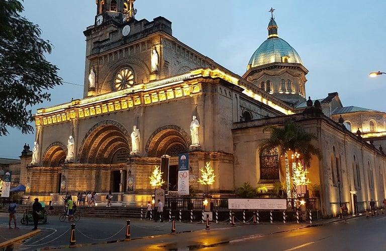 a church with a clock tower in the middle of a street