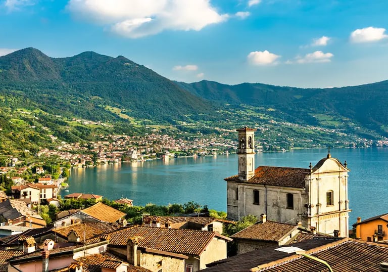 Panoramic view of Lovere on Lake Iseo in Lombardy, Italy, showing terracotta rooftops, a historic church, and the calm blue l