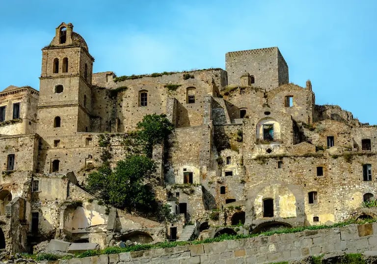 Historic ruins of Craco ghost town on a steep hill in Basilicata, Italy, with ancient stone houses and church tower