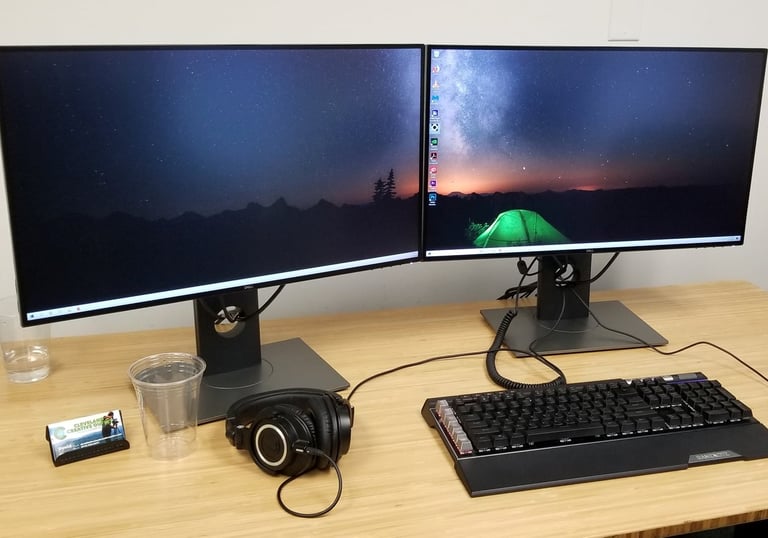 a desk with two monitors and a keyboard