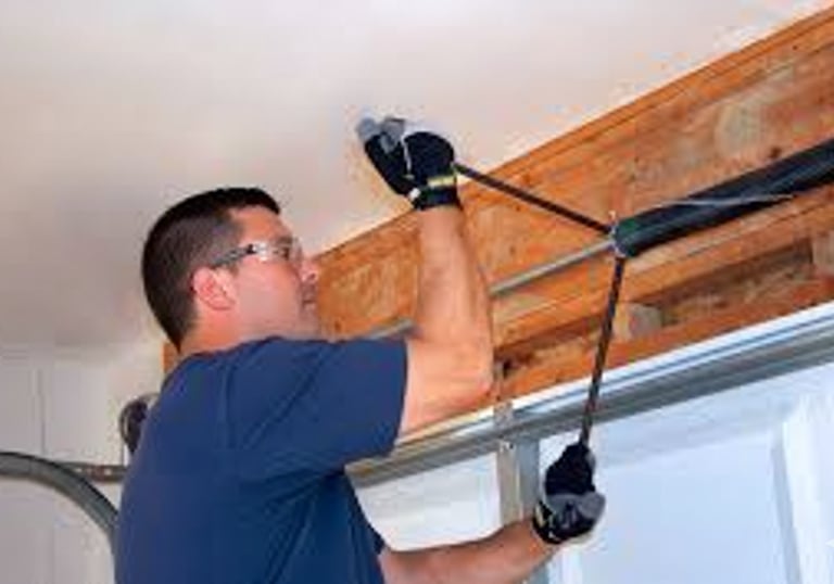 photo of a garage door repair technician repairing a garage door spring 