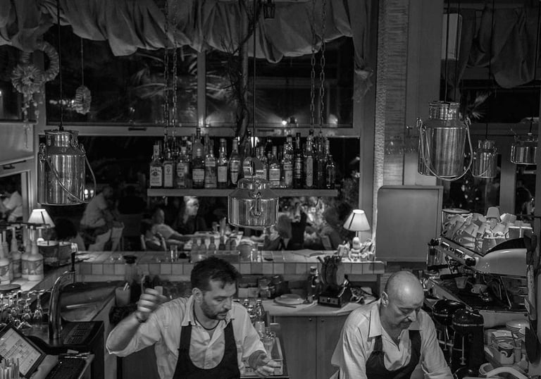 two barmen making at a bar 