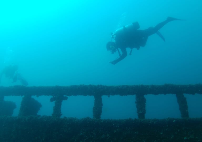 a scuba diver exploring shipwreck in lake huron michigan