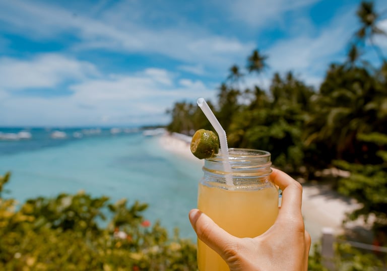 a person holding a drink in a mason jar