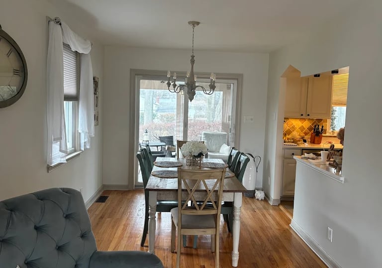 a finished painted dining room with a table and chairs