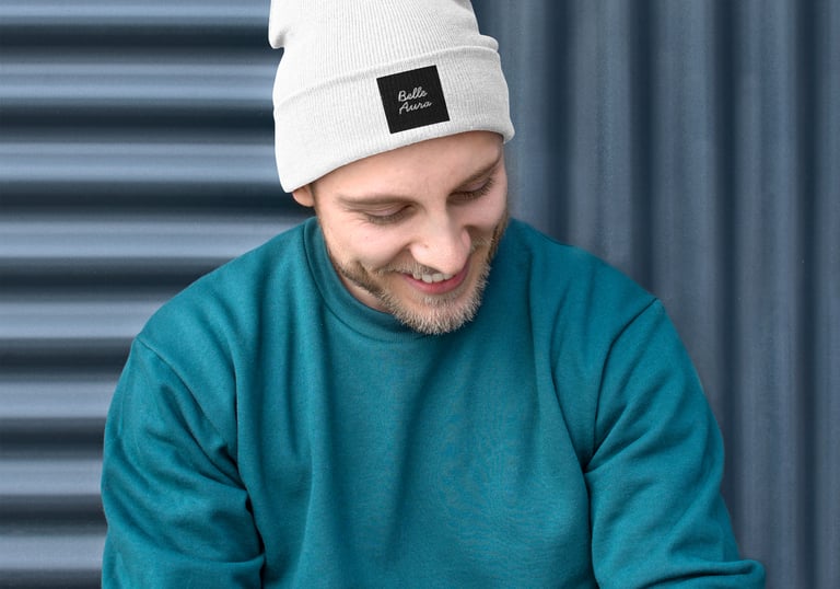 a man in a blue sweater and a white beanie hat