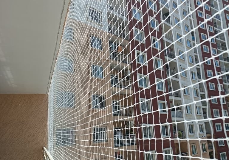 A balcony fitted with sturdy safety nets protecting a playful dog.