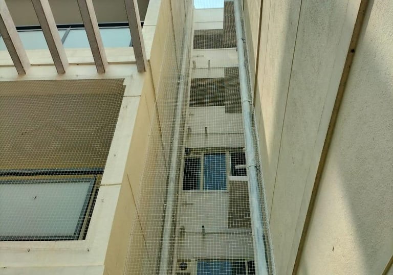 Pigeon netting covering a duct area, blending seamlessly with the building exterior.