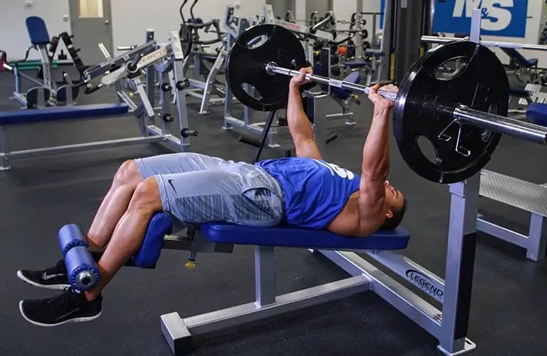 a man is doing a decline bench press in a gym