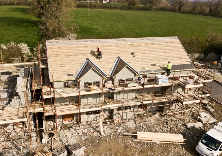 a house being built with a roof and a truck