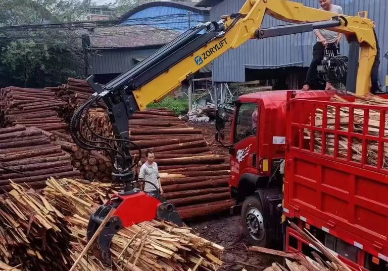 Customer's red truck: yellow ZORYLIFT forestry crane (timber crane) with grapple handling cut logs.