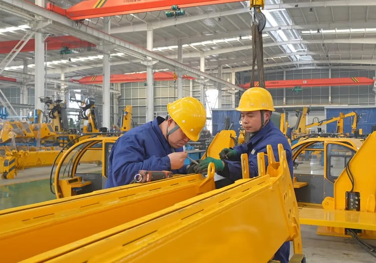 Our team expertly assembles large vehicle mounted cranes in our modern factory, showcasing strong manufacturing capabilities.