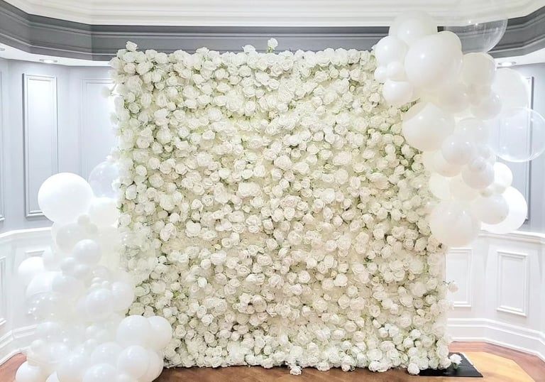 White rose flower wall with 2 white balloon clusters for a graduation party