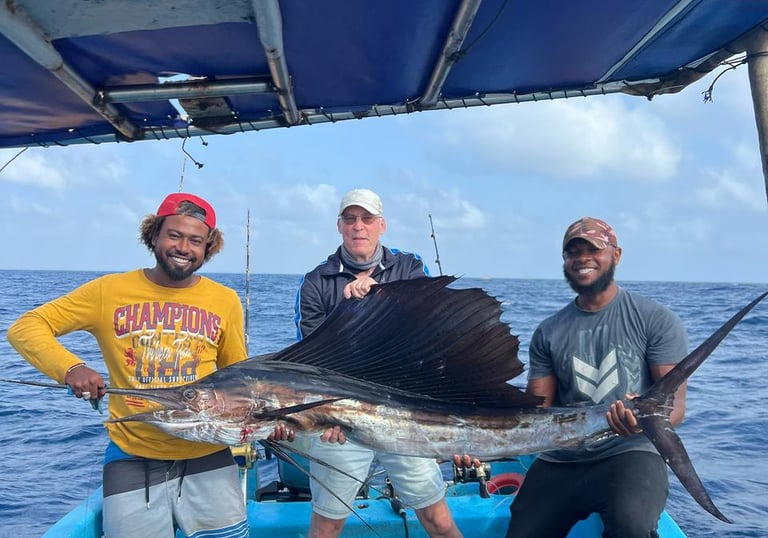 a man holding a sailfish on a boat