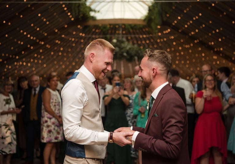 Two men hold hands on their wedding day