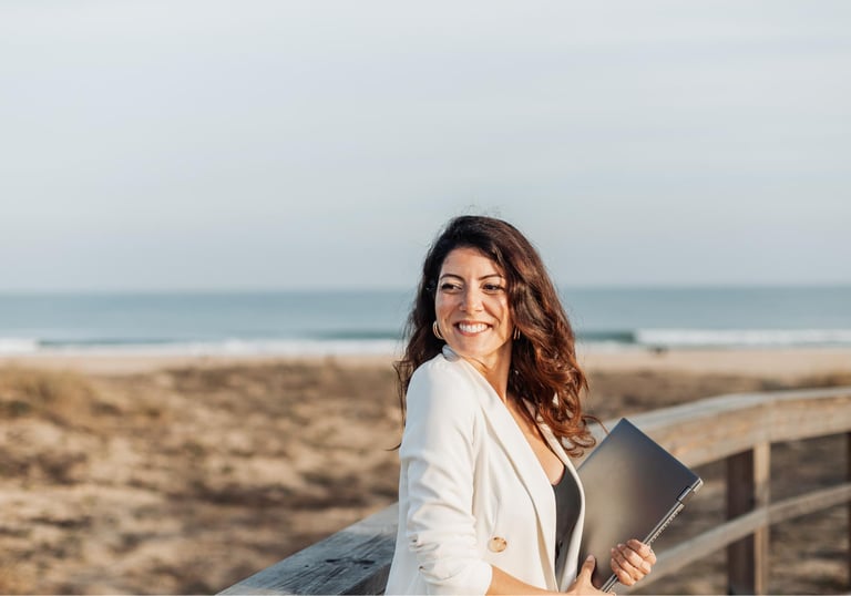 a woman in a white blazer and a laptop computer