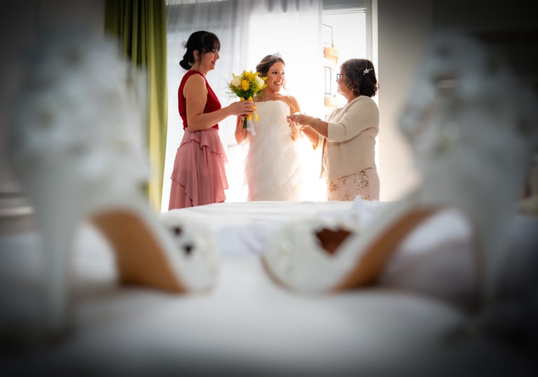 Novia preparándose con su madre y la madrina
