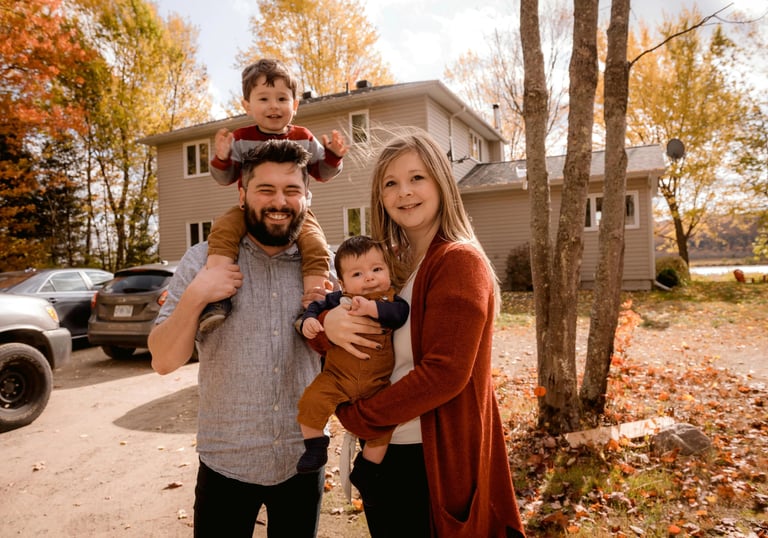 Happy family outside their new home in autumn, representing mortgage options for repeat home buyers