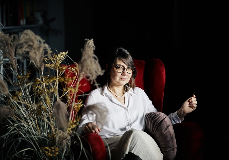 a woman sitting in a chair with a flower in her hand