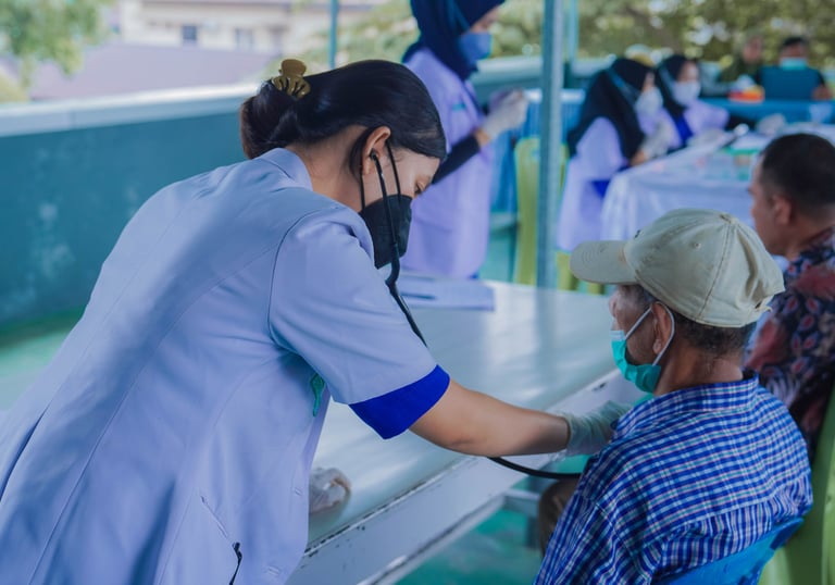 Tenaga medis wanita memeriksa kesehatan pasien lansia dalam layanan kesehatan gratis di daerah t
