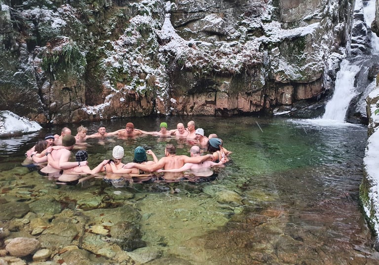 Eine Gruppe von Menschen beim Eisbaden am Wasserfall nach der Wim Hof Methode