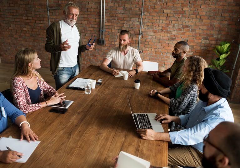 a group of office workers sitting around a table for training