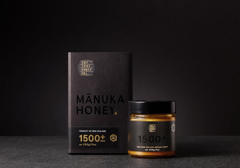 Product photography - a jar of honey sitting beside the packaging on a black background