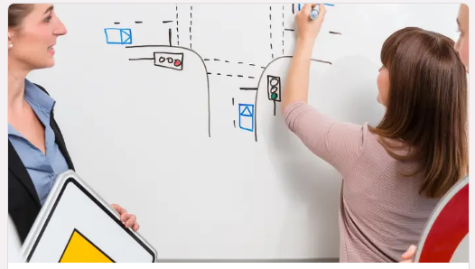 Mädchen, das eine Aktivität an einem Tafel zum Thema Verkehrssicherheit in einem Kurs durchführt.